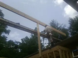 Carpenter setting a ridge beam over a new addition frame — Ice Dam Removal by Roofing Brothers in Rancho Santa Fe