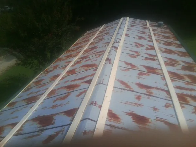 Rusted metal roof panels with new wood purlins before replacement — Storm Damage Roof Repair in Rancho Santa Fe by Roofing Brothers