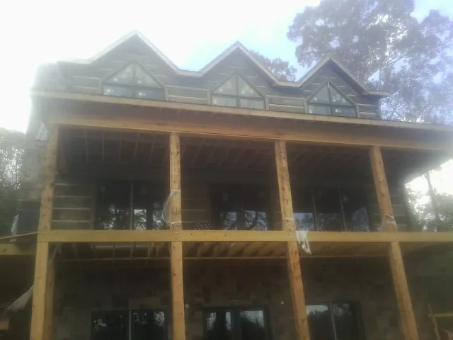 Dormers and porch framing on a large log home under construction — Roof Coating work by our crew in Rancho Santa Fe