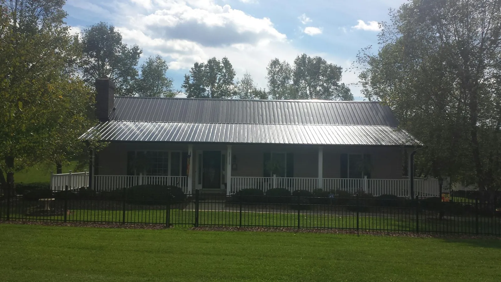 Gray metal roof on a brick ranch with a full width front porch — Gutter Guard Installation work by our crew in Rancho Santa Fe