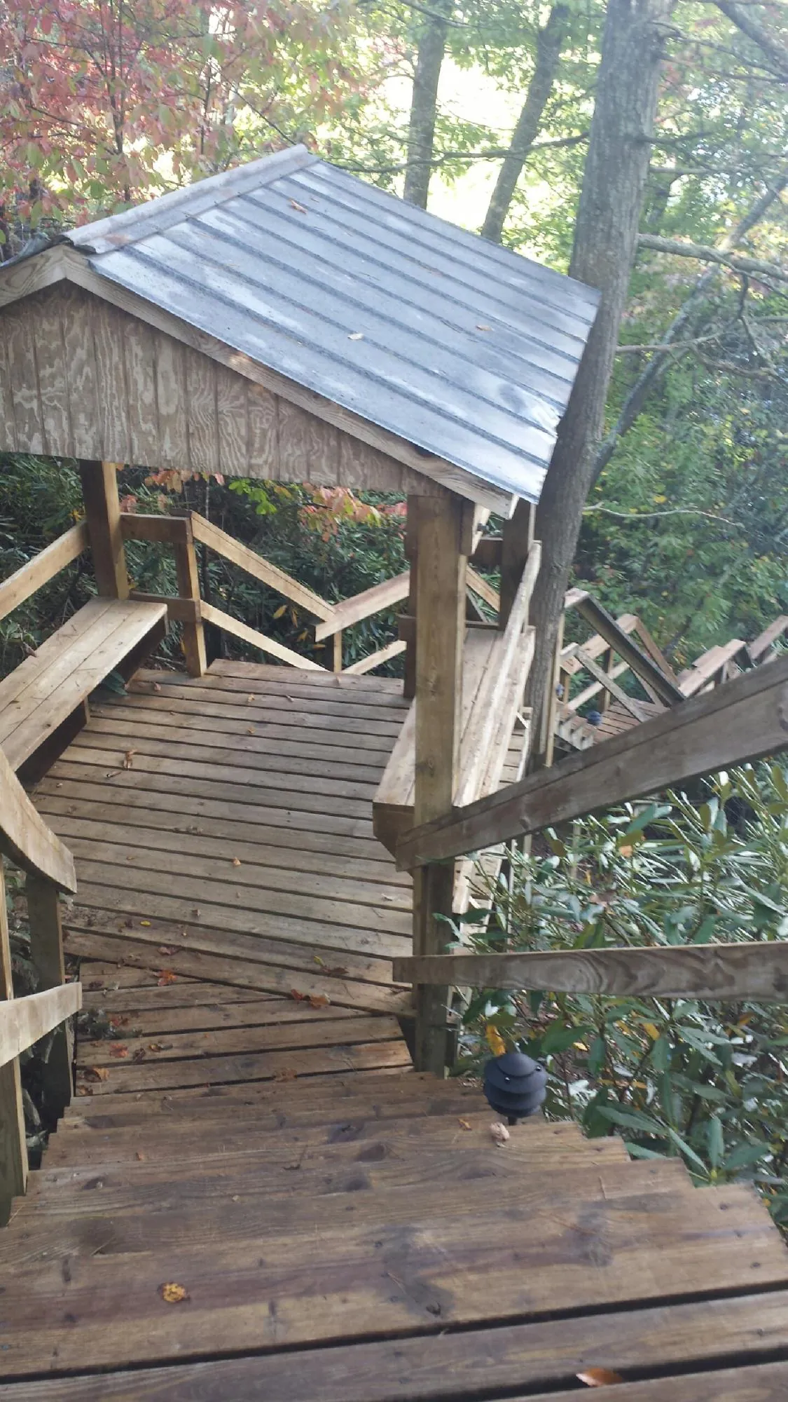 Metal roofed shelter over wooden steps on a wooded walkway — Skylight Repair & Installation work by our crew in Rancho Santa Fe